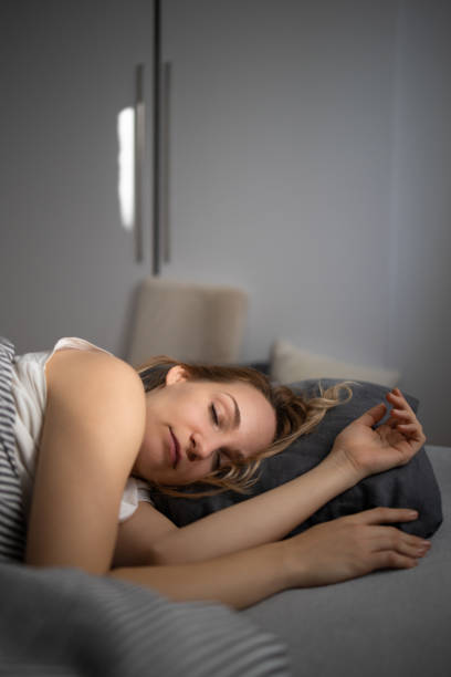 istock Pretty, young woman sleeping in her bed 1350998093