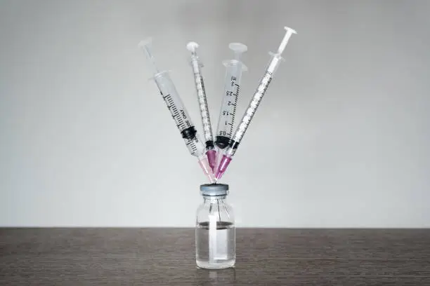 Photo of A vaccine vial with 4 syringes.