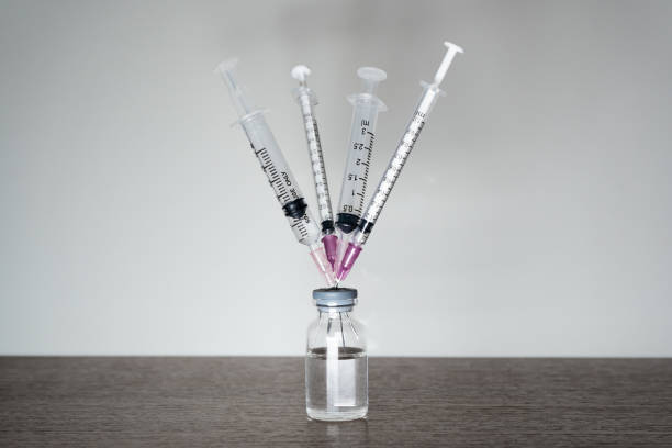 a vaccine vial with 4 syringes. - syringe vaccination vial insulin imagens e fotografias de stock