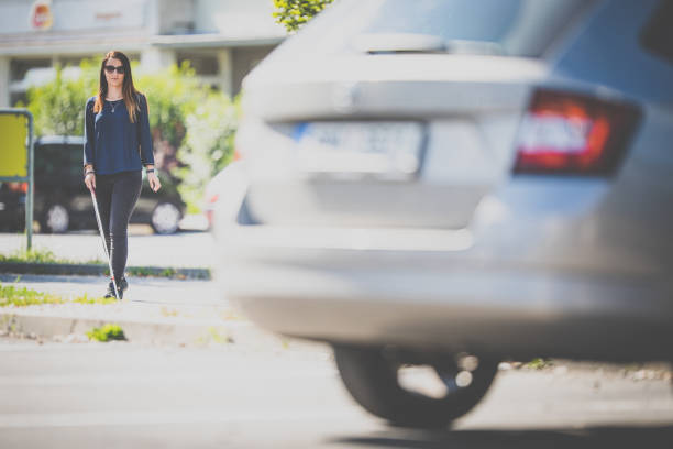 istock Blind woman walking on city streets, using her white cane 1350999416