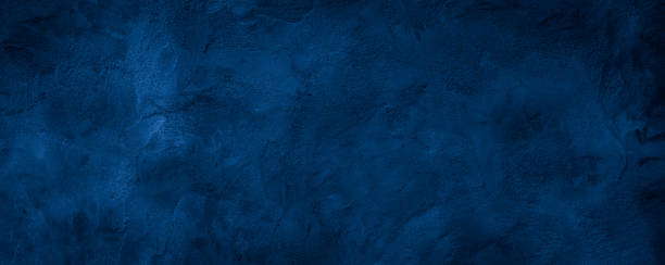 Dark blue rough grainy stone or concrete wall texture background stock photo