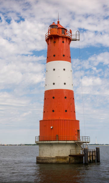 istock Lighthouse standing in water against cloudy sky 1351000207
