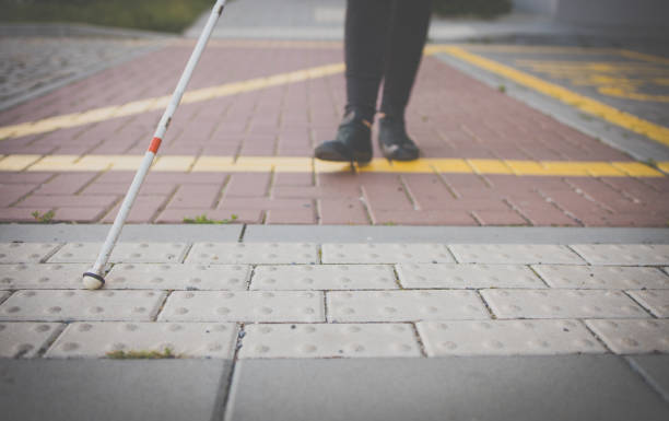 istock Blind woman walking on city streets, using her white cane 1351000282