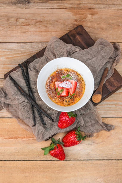 Creme Brulee Dessert with Vanilla and Strawberries in rustic kitchen