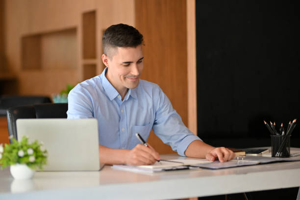 istock Handsome caucasian businessman work and write on paperwork. 1351003969