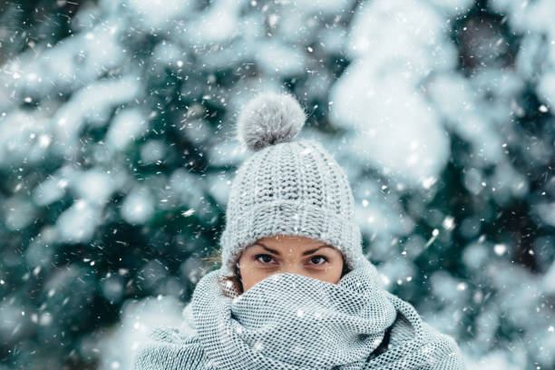 Beautiful young woman wearing scarf and a a hat on a cold winter day Portrait of a beautiful young woman wearing scarf and a a hat on a cold winter day during snow frost face stock pictures, royalty-free photos & images