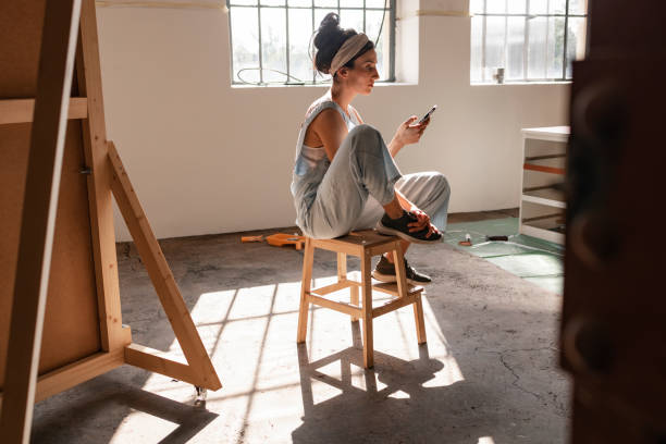 istock Young Woman Sitting on a Chair and Using Mobile Phone 1351008593