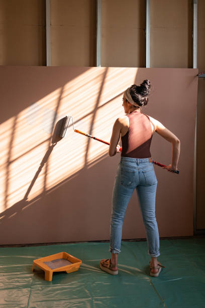 istock Unrecognizable Woman Painting Panel with Paint Roller 1351008603