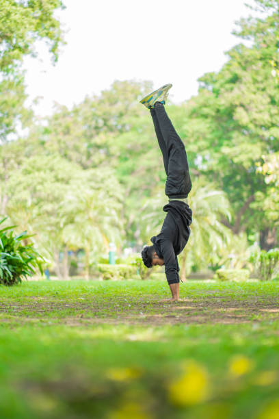 istock Young guy doing handstand in the park 1351008703