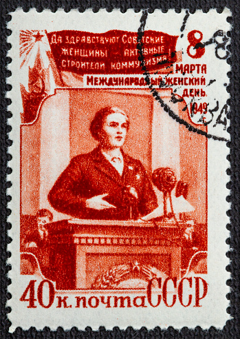 Soviet postage stamp from 1976 with drawings of Marx and Lenin and text in russian \
