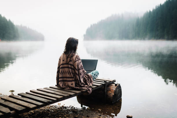 istock Woman Relaxing In Nature And Using Technology 1351009393
