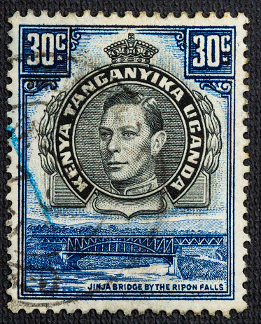Postage stamp printed by Kenya, Uganda and Tanganyika, that shows Jinja Bridge and Ripon Falls and portrait of king George, circa 1938.