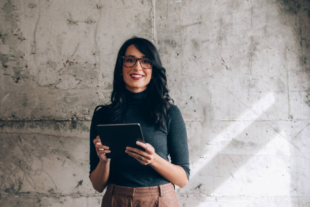 istock Portrait of a Beautiful Female Office Worker Using a Digital Tablet in the Office 1351009886
