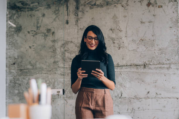 istock Beautiful Female Office Worker Using a Digital Tablet in the Office 1351009911