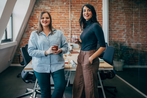 istock Two Smiling Business Colleagues Chatting over a Coffee Break at the Office 1351009925