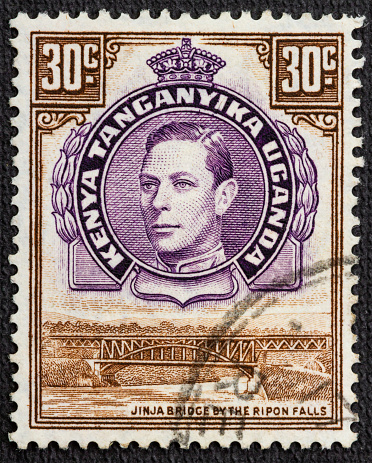 Postage stamp printed by Kenya, Uganda and Tanganyika, that shows Jinja Bridge and Ripon Falls and portrait of king George, circa 1938.