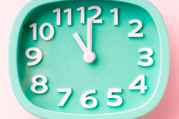 istock 11:00, 23:00. Green clock on pink background 1351011080