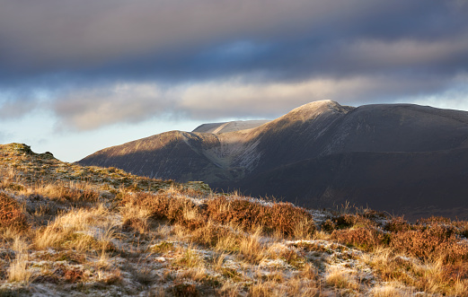 A winters morning sunrise catching the mountain tops of Eel Crag, Crag Hill with Grasmoor in the distance. Lake District UK.