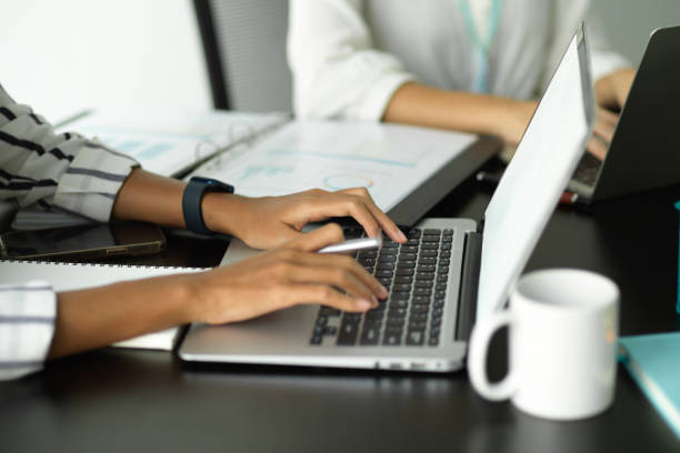 istock Female officer typing on keyboard while discussing with her colleagues. 1351012065