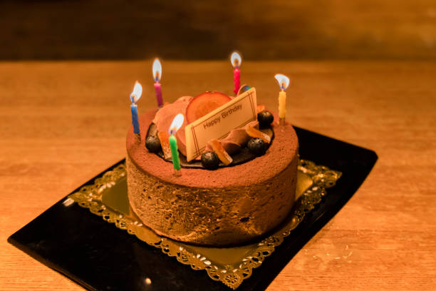 istock Chocolate-flavored birthday cake with candles lit 1351013562
