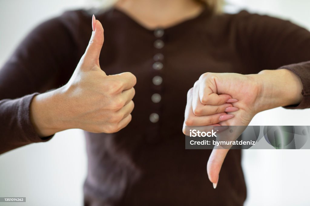 Giving thumbs up and down Thumbs Up Stock Photo