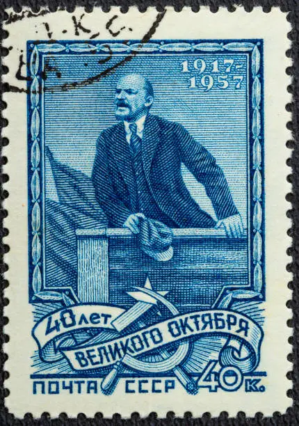 A postage stamp printed in the USSR depicts Vladimir Lenin Ulyanov on the podium, 40th anniversary of the Great October Revolution, Lenin Series, circa 1957.