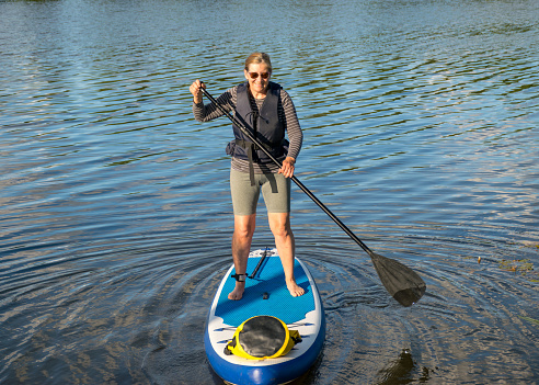 landscape with a woman on a sup board