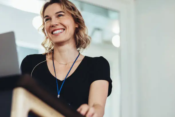 Photo of Confident businesswoman standing at podium