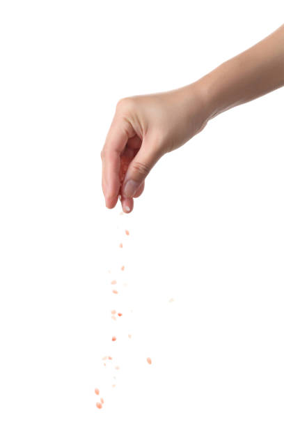 istock Hand sprinkle pink salt isolated on white background 1351020865