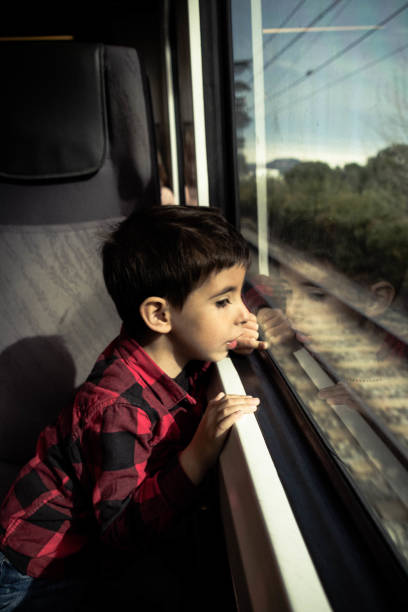 istock Amazed child looks out the window while traveling by train. 1351022503