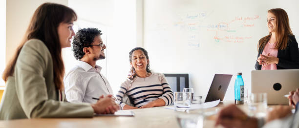 istock Diverse young businesspeople smiling during a presentation in an office 1351025480