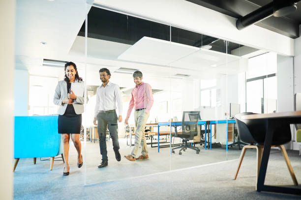 istock Smiling businesspeople walking together through a modern office space 1351025499