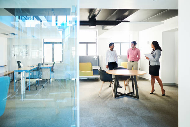 istock Diverse young businesspeople talking together around an office table 1351025512