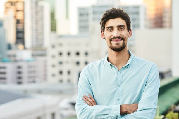 istock Smiling young businessman standing outside on an office building terrace 1351025521