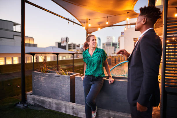 istock Two diverse coworkers talking on a rooftop terrace after work 1351025552
