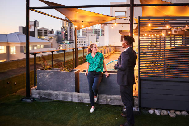 istock Smiling coworkers talking on a rooftop terrace after work 1351025571