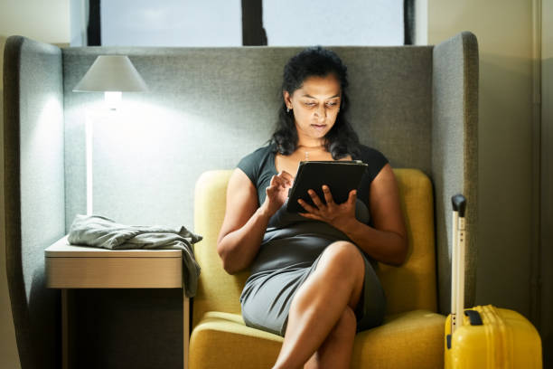 Businesswoman using digital tablet while waiting at airport lounge