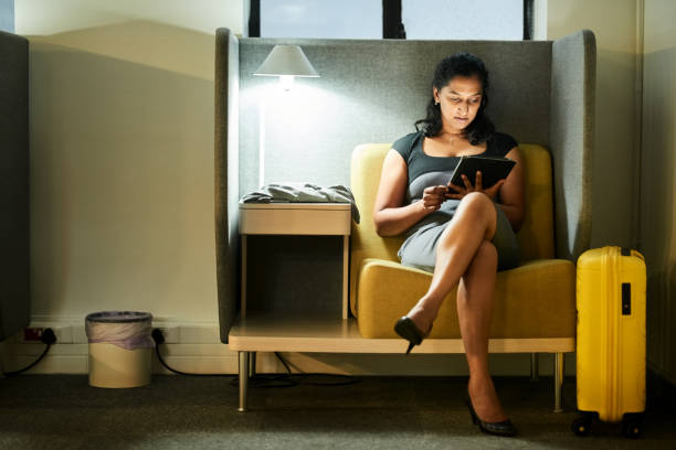 Woman waiting at airport lounge using digital tablet