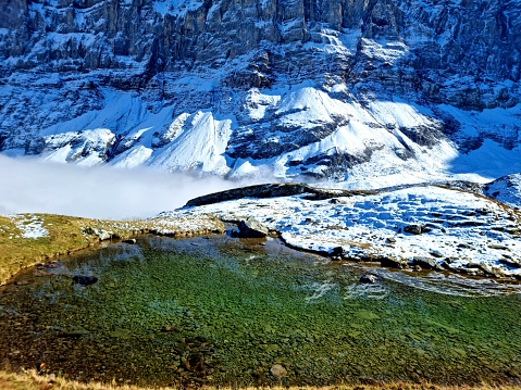 Mountain idyll with a little lake and snowcovered rocks. The image was captured in the swiss alps (canton of glarus) at an altitude of 2300m.