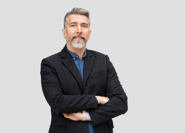 istock Handsome mature man with arms crossed studio portrait, isolated on grey background 1351031406