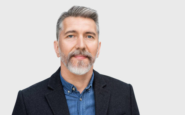 Handsome mature business man studio portrait, isolated on grey background