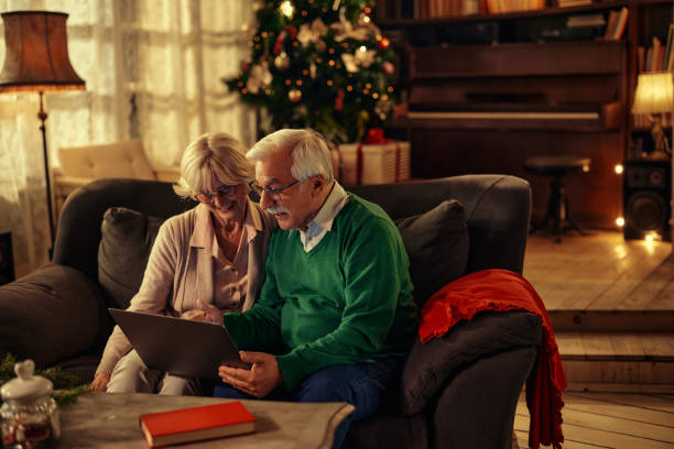 para siedząca na kanapie i korzystająca z laptopa - couple laptop computer digital tablet zdjęcia i obrazy z banku zdjęć