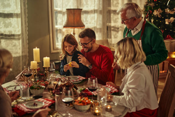 wesoła rodzina przy stole na świąteczny lunch w domu - home decorating dining room indoors dining zdjęcia i obrazy z banku zdjęć