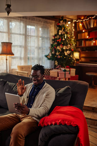 istock Happy black man in a Christmas mood using tablet. 1351035942