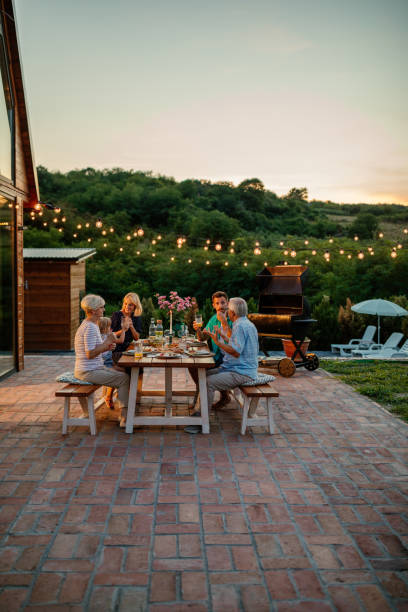 istock Cheerful three generations family having dinner together around a table in the backyard 1351036495