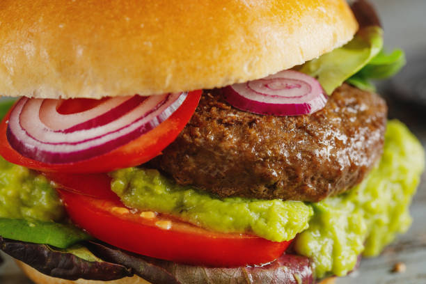 istock Burger with meat and avocado sauce served on wooden table 1351037926