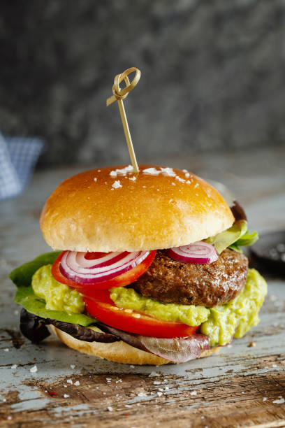 istock Burger with meat and avocado sauce served on wooden table 1351037979