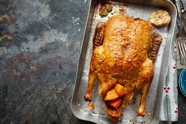 istock Baked roasted duck with vegetables on pan on stone background 1351038075