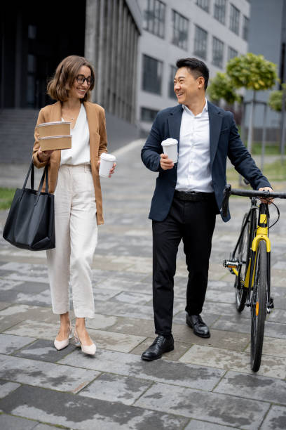 istock Business people walk, drink coffee and talk 1351038084