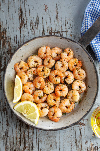 istock Tasty appetizing fried shrimps on pan on dark stone background. 1351038132